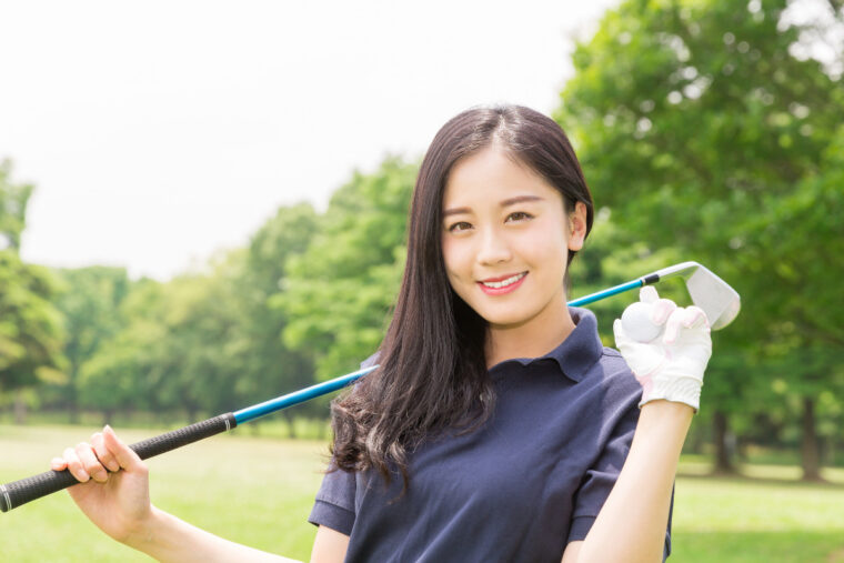 ゴルフクラブとボールを持った日本人女性ゴルファーの写真